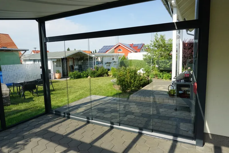 Szklane ściany przesuwne zamykające taras, widok z wnętrza na ogród